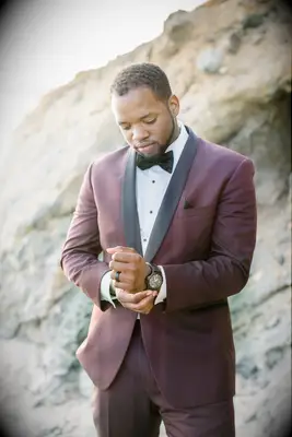 Groom in a burgundy suit on his wedding day