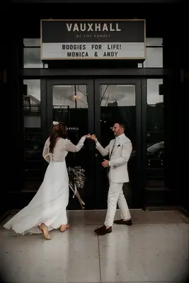 A bride and groom dance in front of a dance hall