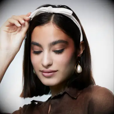 White bow headband by Lele Sadoughi. 