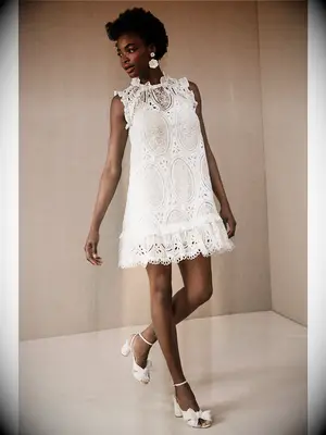 Short wedding dress with eyelet lace and ruffled neckline and hemline
