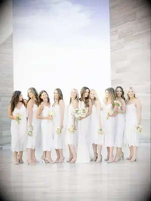 A bride and her bridesmaids all wearing white