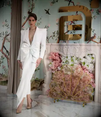 White wedding suit with a bow at the waist. 
