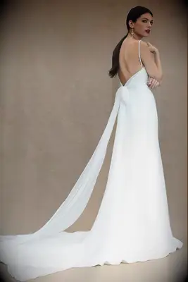 Long elegant wedding dress with a bow trailing in the back. 