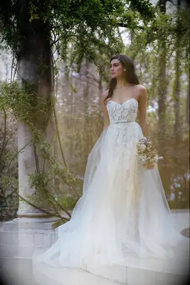 Strapless wedding dress with bow by Anne Barge. 