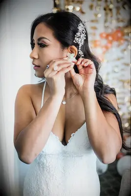 Bride putting earrings on