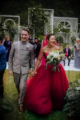 Bride in modern red wedding dress and groom in traditional tang suit in gray