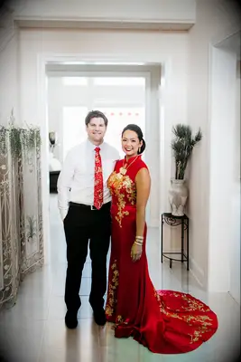 Groom wearing Western suit and red tie with gold embroidery