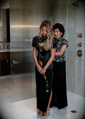 Bride in black silk qipao with embroidered flowers