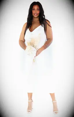 Model wears a white slip dress with platform high heels. 