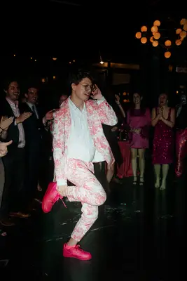 Man dancing while wearing a pink and white suit