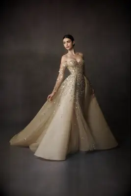 Gold off-the-shoulder wedding dress with long sleeves by Nicole + Felicia