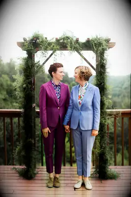 Two women holding hands at the altar wearing lesbian wedding suits from Sharpe Suiting