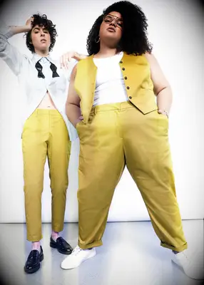 Models wearing yellow cropped dress pants and vest from WILDFANG