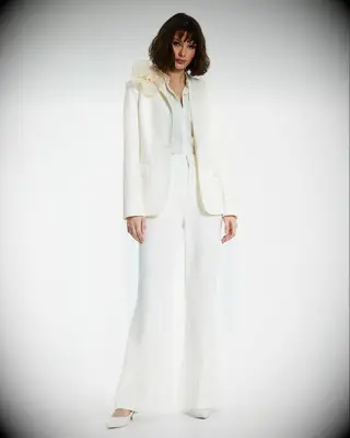 Tailored white pantsuit with flower shoulder detail