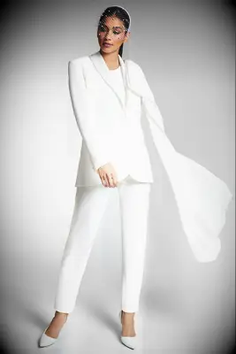 Woman wearing a white slim pantsuit with cape