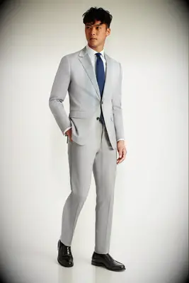 Man wearing a light gray suit with navy tie