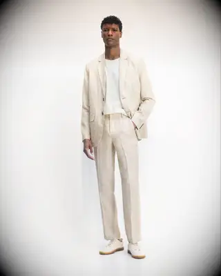 Man wearing a relaxed beige linen suit with white shirt