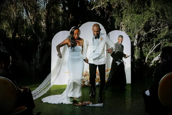 A bride and groom jump the broom