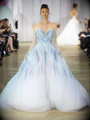 Pastel blue wedding ball gown with off-the-shoulder sleeves and crystal embellishments