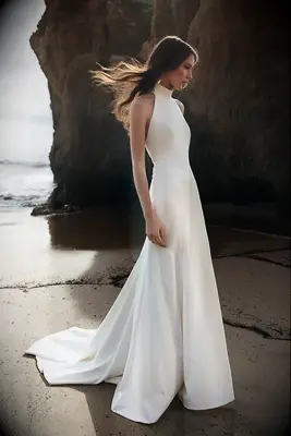 Bride wearing high neck wedding dress on a beach