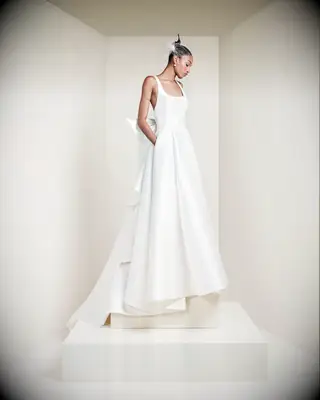 Bride wearing a white wedding down with bow detail made out of mikado fabric