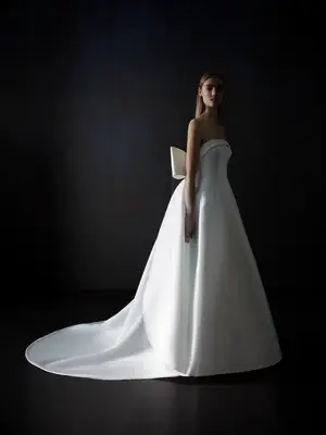 Bride wearing white strapless pique wedding dress with bow detail