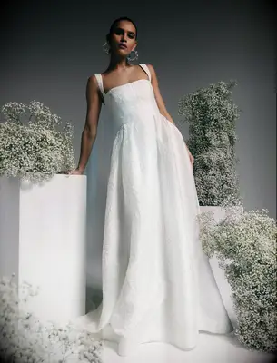 Bride wearing a white wedding dress made out of Brocade fabric