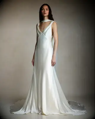 Bride wearing white silk wedding gown with deep v and scarf detail