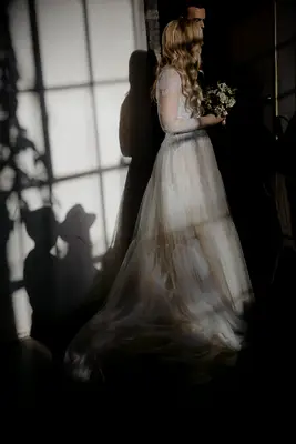 Bride wearing a cream, tulle long sleeve wedding gown