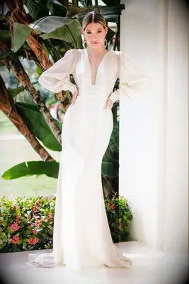 Bride wearing a cream long sleeve deep v charmeuse wedding dress