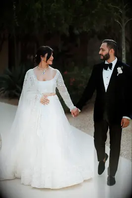 Bride wearing square neck wedding dress with groom 
