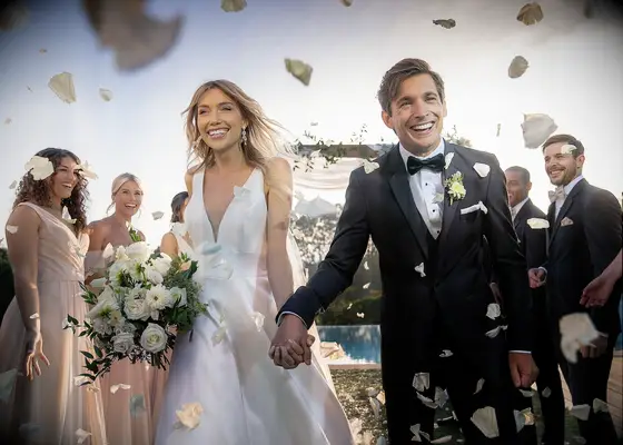 Bride and groom holding hands at wedding recessional, wedding suit from Generation Tux