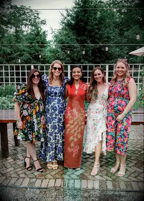 Guests wearing floral and bright dresses at vineyard wedding