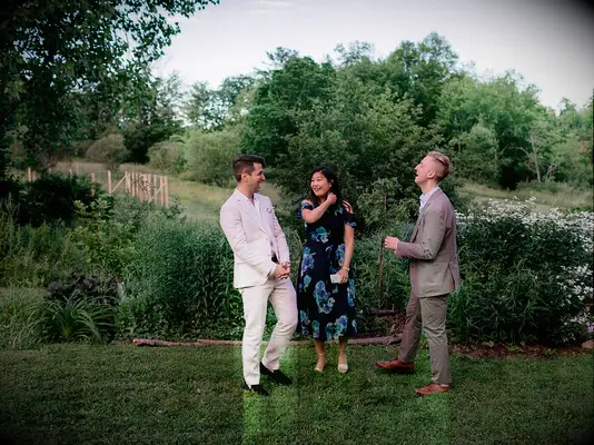 Guests at vineyard wedding wearing light colored suits and floral dress