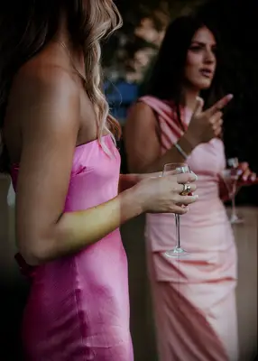 Guests wearing pink dresses at vineyard wedding