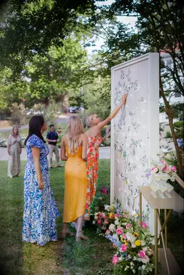 Guests at vineyard wedding wearing bright floral dresses 