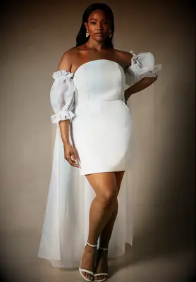 White plus size mini dress with puff sleeves and cape for engagement from Eloquii
