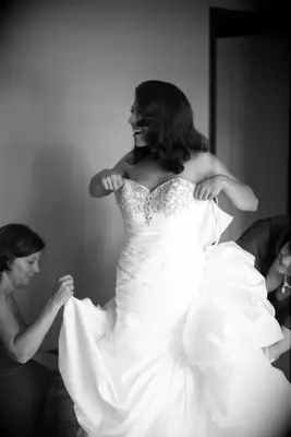 Bride getting into wedding dress 
