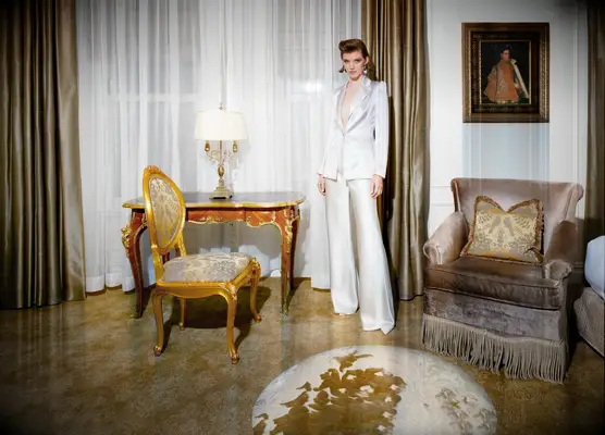 Model poses in white pant suit
