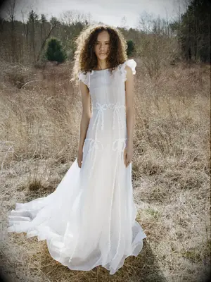 model wearing a-line wedding dress stands in open field