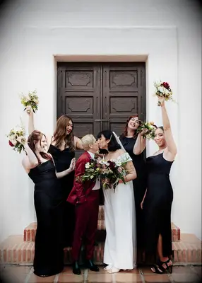 Couple surrounded by bridesmaids in black dresses
