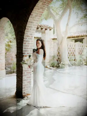 Bride wearing off the shoulder wedding dress with chapel length train.