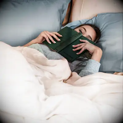 Woman laying in bed with silky sheets 25 year wedding anniversary gift