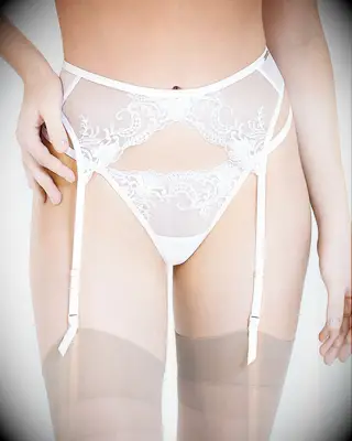 Woman wearing white suspender belt and thong