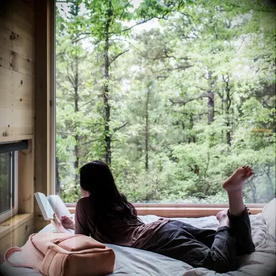 Woman reading a book in a cabin