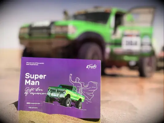 Tinggly Superman experience gift box in front of off-road vehicle
