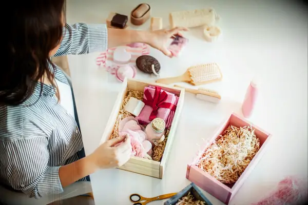 Woman packs a spa-themed gift box for a bridal shower. 
