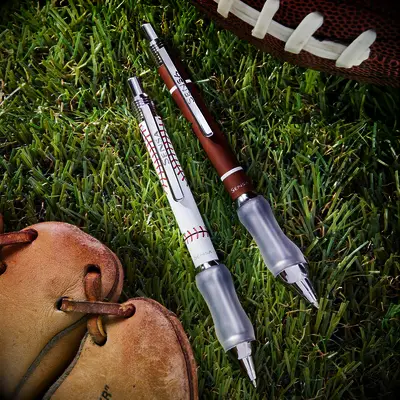 Baseball and football themed pens pictured on grass