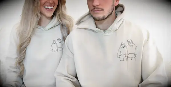 Couple wears matching sweatshirts with an outline of their photo on the chest. 