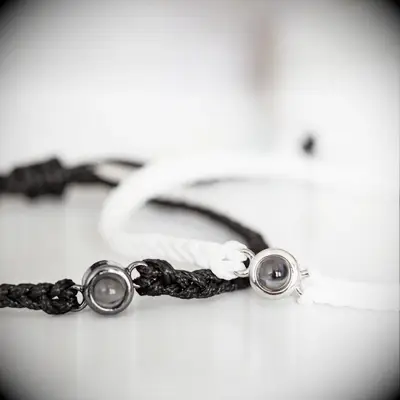 Two braided bracelets with beads that contain treasured photographs. 